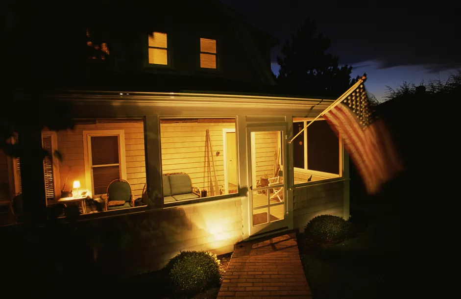 porch with american flag at night 86061656 59f0d2ce0d327a00109d2d0e 1